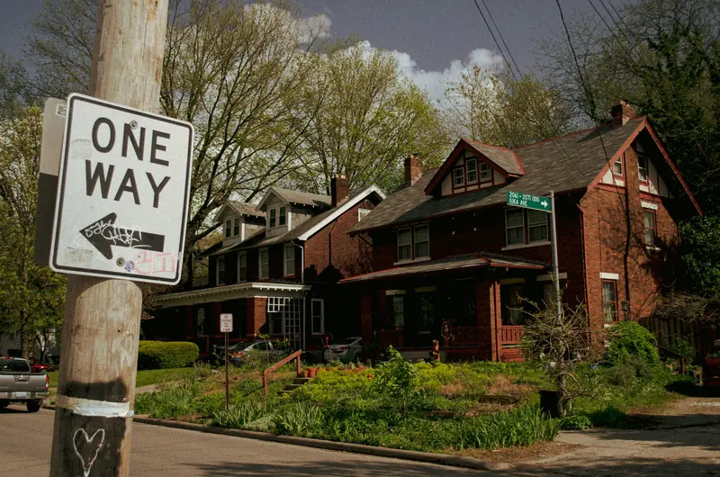 Brick houses with front porches on Iuka Avenue near the Ohio State campus, behind a one-way sign